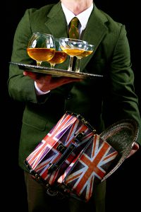 Close-up shot of a man holding a plate of wine glasses and a box with the UK flag on it