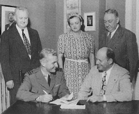 Lt. L. Newell Tarrant signs his contract as RLT's first fulltime professional director.